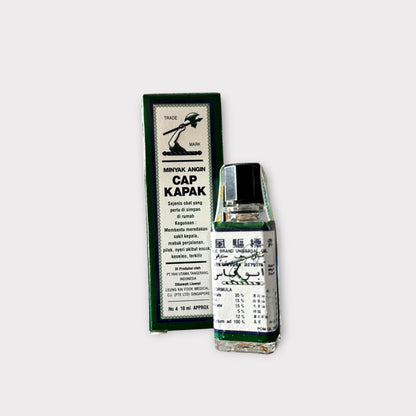 Massageöl Cap Kapak von Amboina B.V, Nahaufnahme der Flasche mit Etikett und Massageöl-Textur in der Hand.