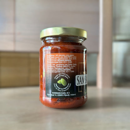 Sambal Peteh von Vanka Kawat, scharfe indonesische Sambal mit roten Chilis und Gewürzen, in einer offenen Glasdose.